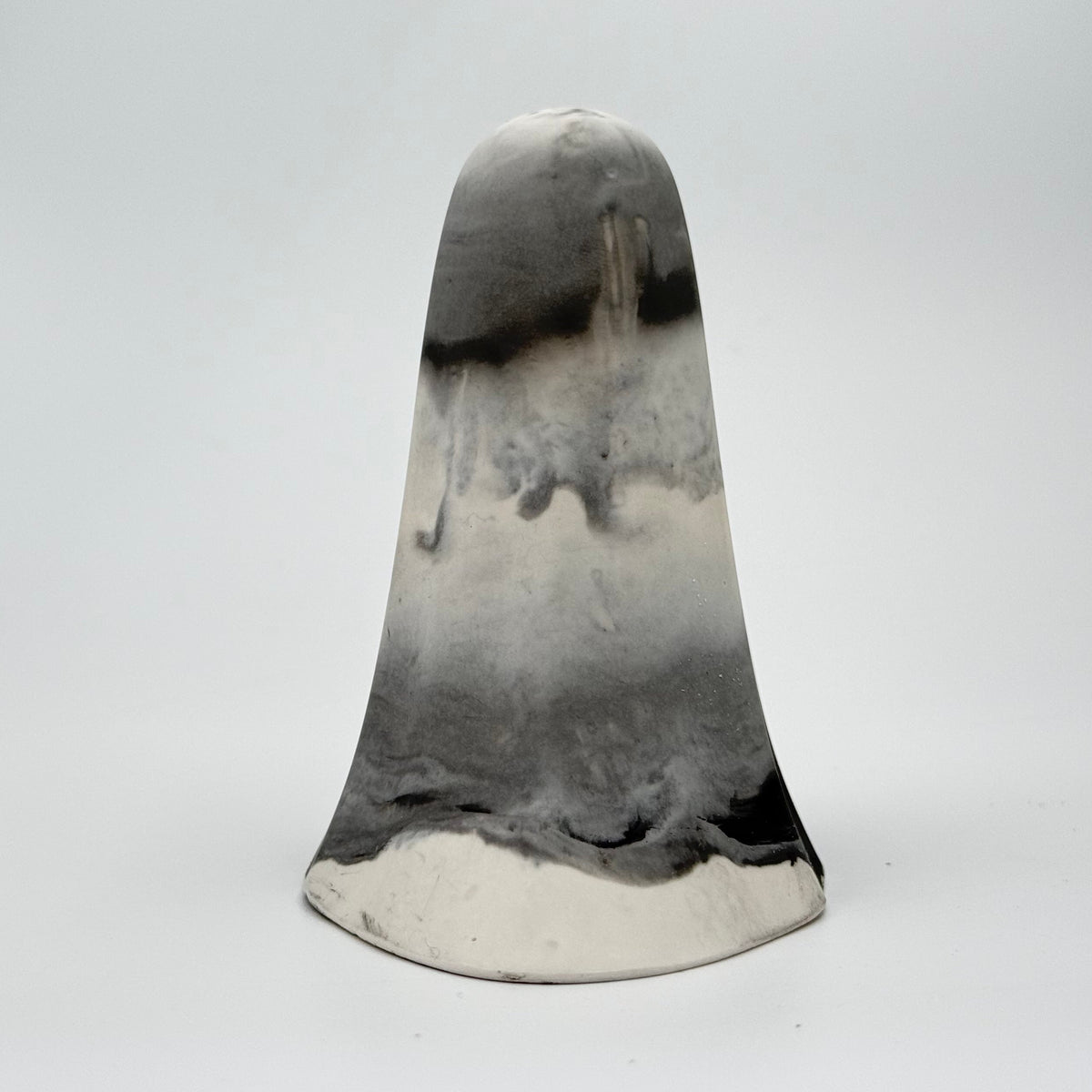 A grey and white marbled handmade ghost figurine by The Nordic Ghost Merchants. Its colouring resembles fog. Rear view