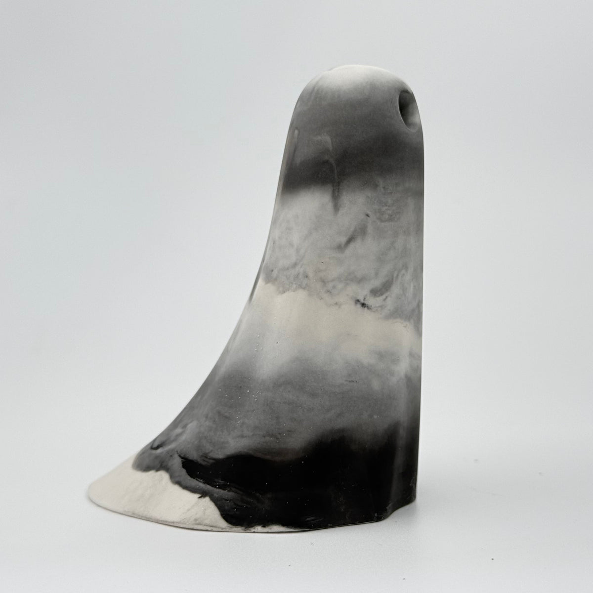 A grey and white marbled handmade ghost figurine by The Nordic Ghost Merchants. Its colouring resembles fog. Side view
