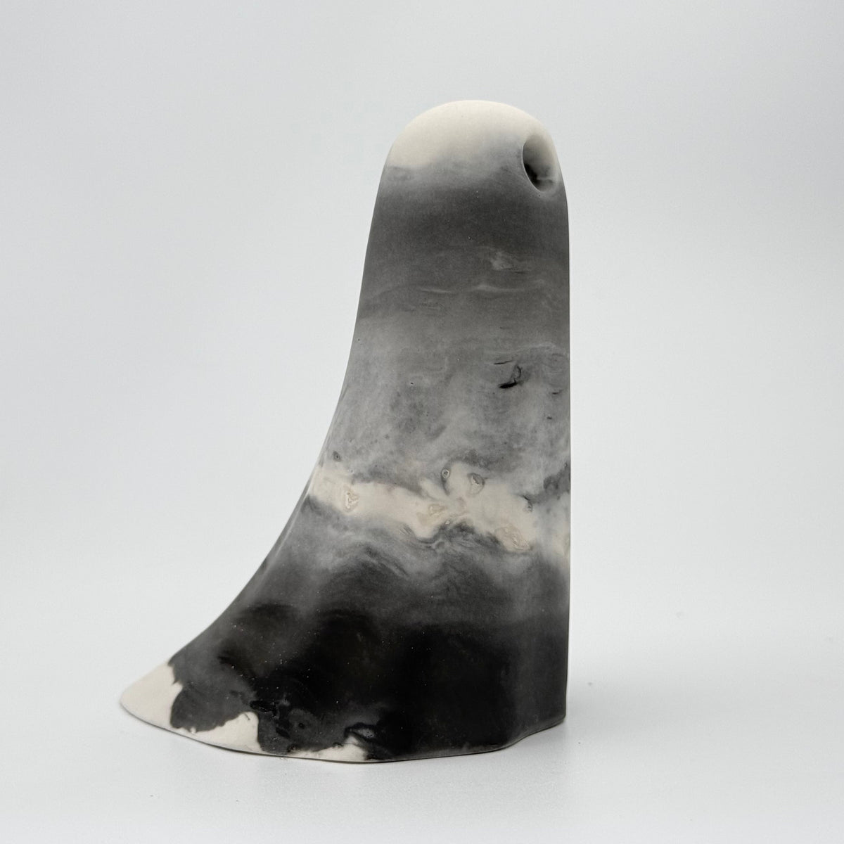 A grey and white smoky ghost figurine handmade by The Nordic Ghost Merchants. Side view